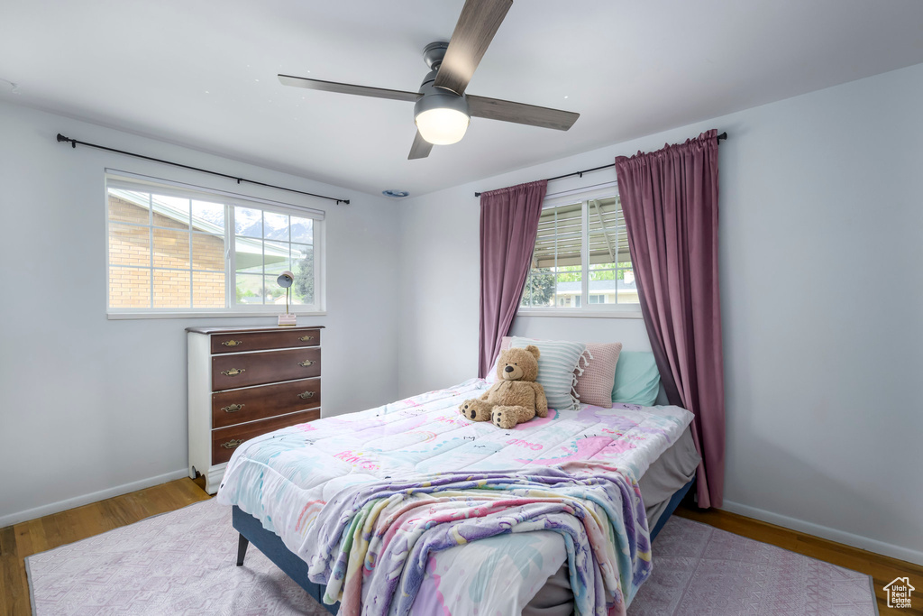 Bedroom featuring wood finished floors, baseboards, and a ceiling fan