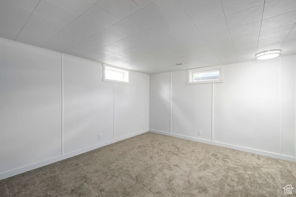 Below grade area with carpet flooring and plenty of natural light