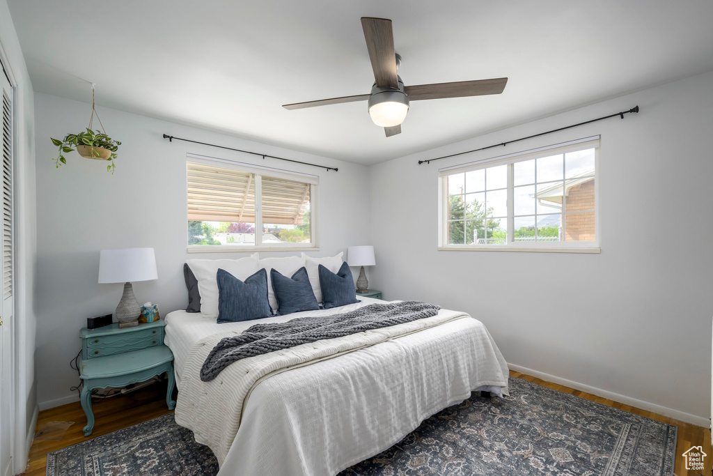 Bedroom with baseboards, wood finished floors, a ceiling fan, and a closet