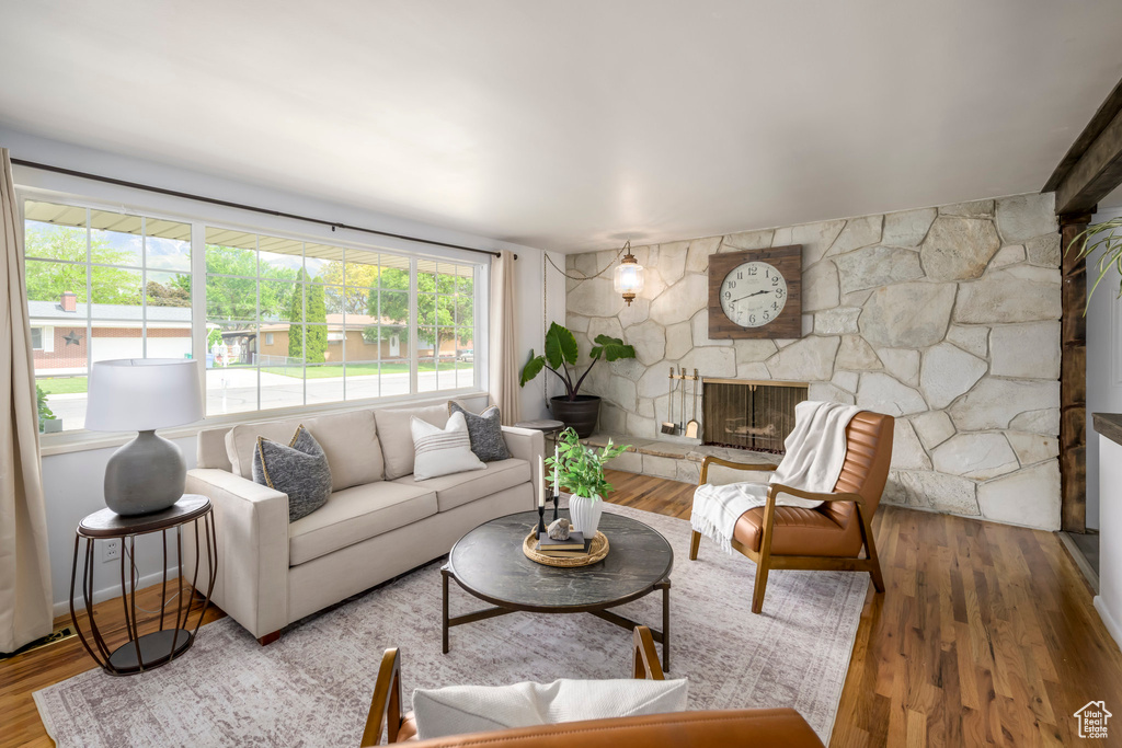 Living area featuring a stone fireplace and wood finished floors