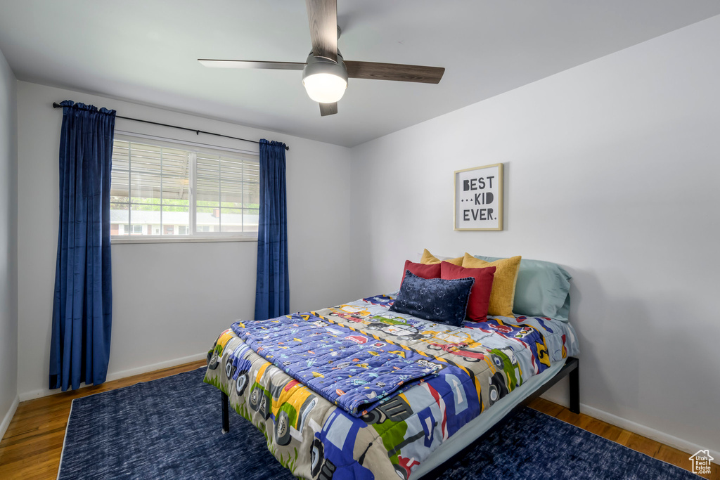 Bedroom featuring wood finished floors, baseboards, and ceiling fan