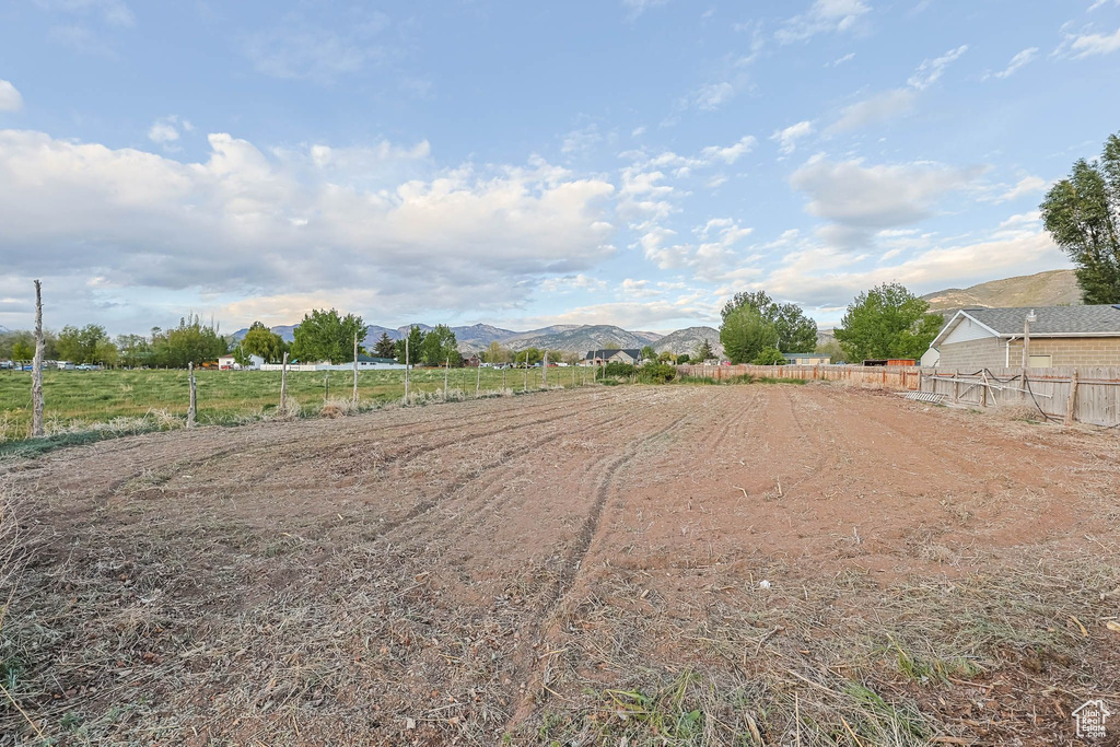 View of yard with a mountain view, fence, and a view of countryside