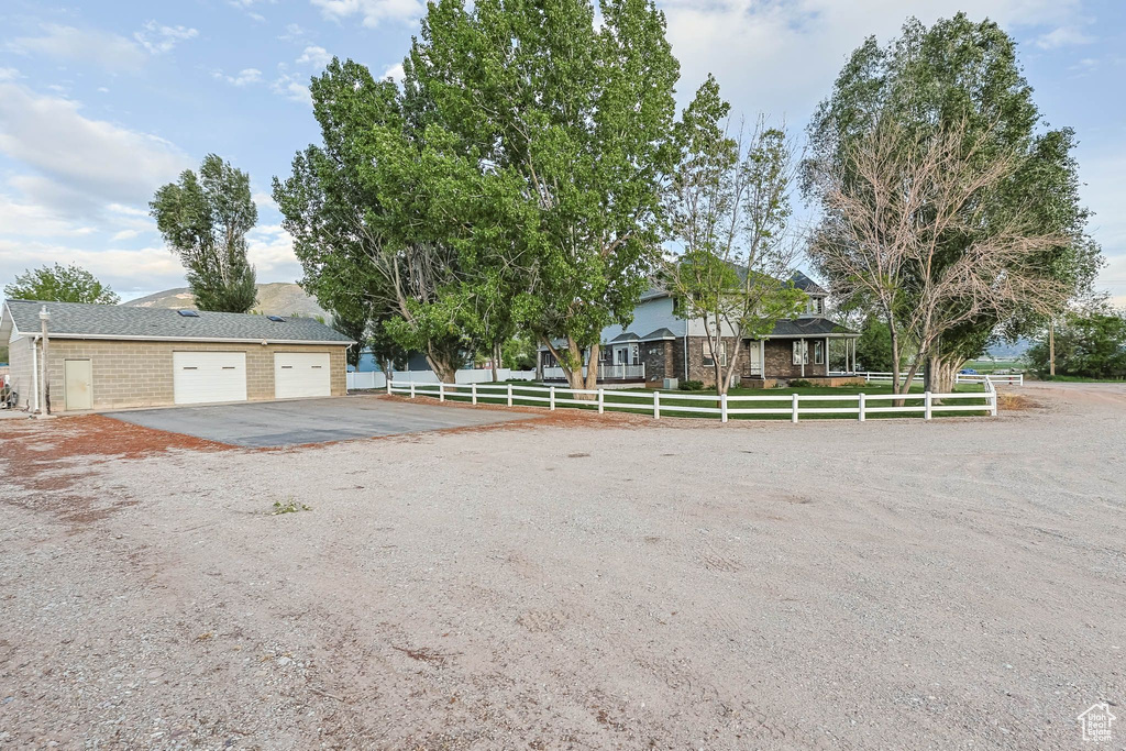 View of front facade featuring fence, asphalt driveway, and brick siding