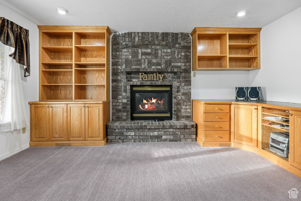 Unfurnished living room with carpet, a fireplace, and recessed lighting