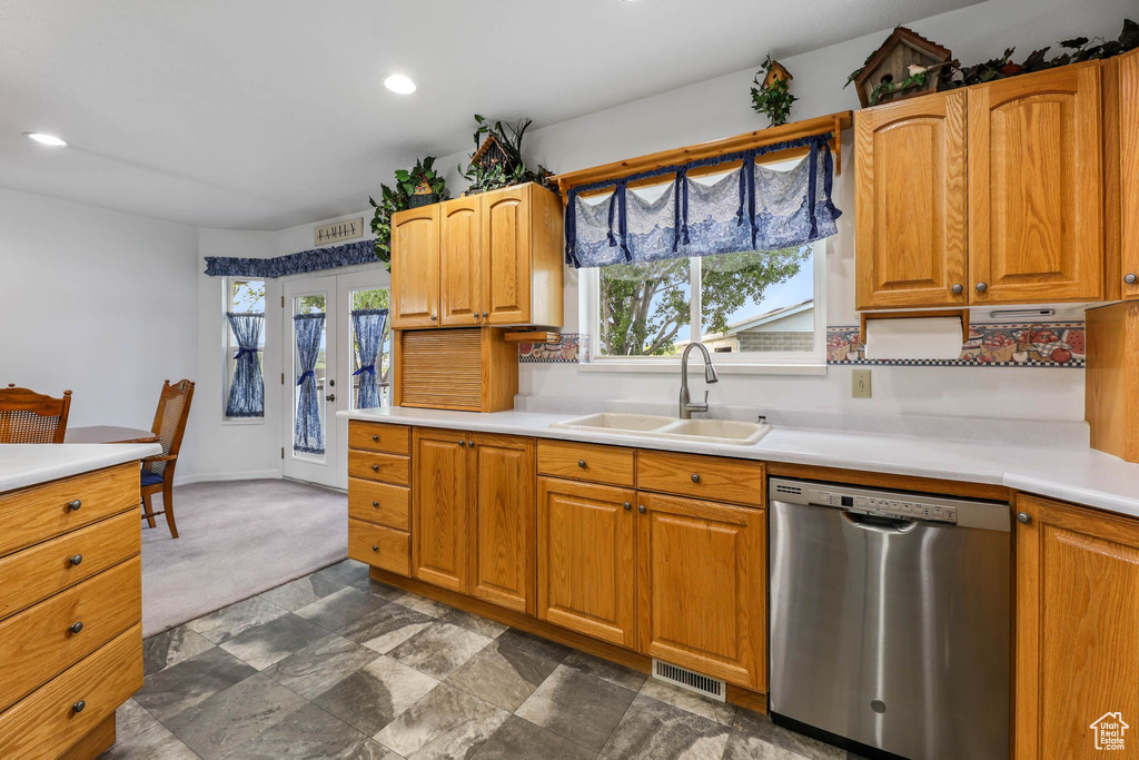 Kitchen with stainless steel dishwasher, a sink, healthy amount of natural light, light countertops, and recessed lighting