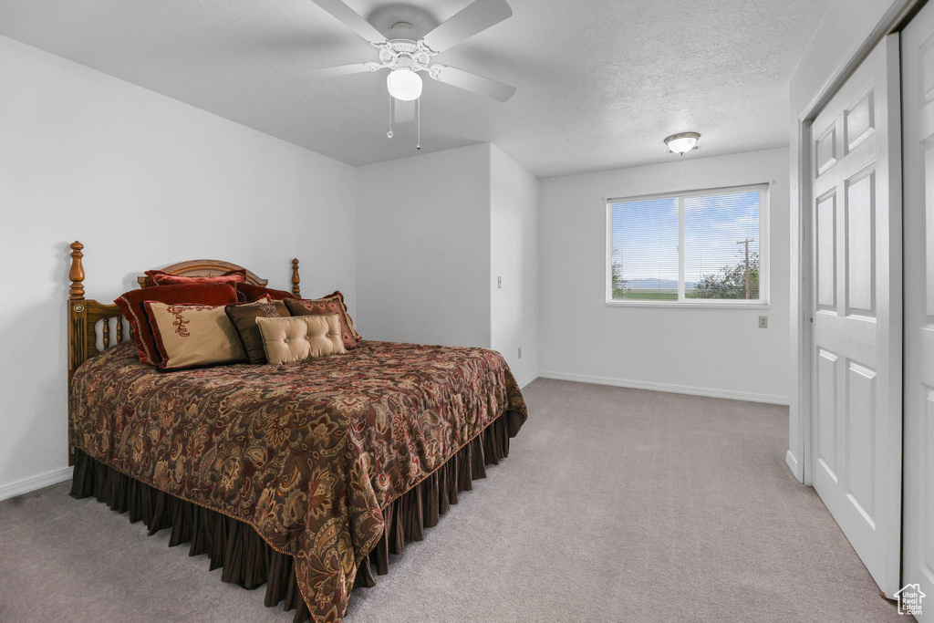 Bedroom with carpet floors, baseboards, and a ceiling fan