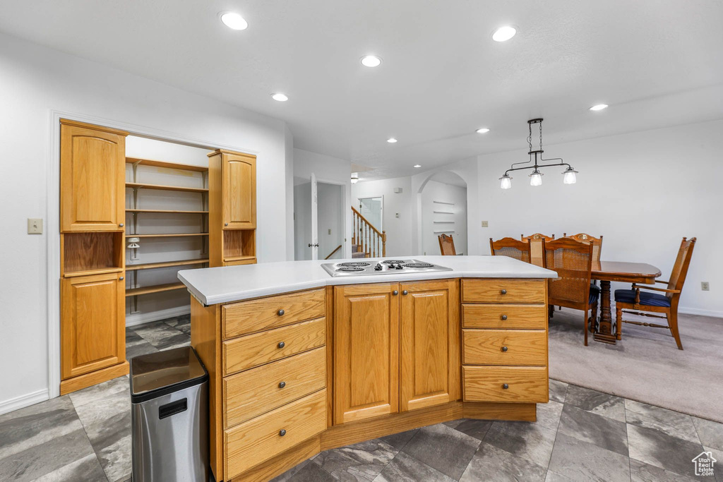Kitchen featuring white electric stovetop, recessed lighting, light countertops, baseboards, and arched walkways
