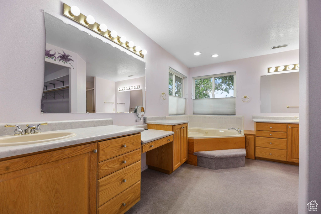 Full bathroom with two vanities and a garden tub