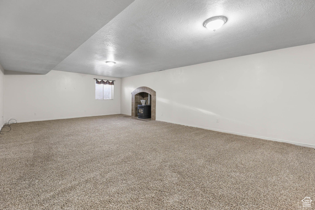 Bonus room featuring a textured ceiling, baseboards, and carpet flooring