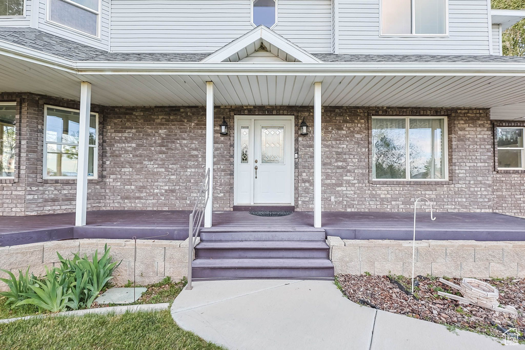 Property entrance with covered porch and brick siding