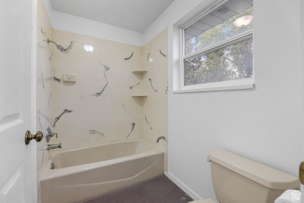 Full bathroom featuring toilet, shower / bathtub combination, and baseboards