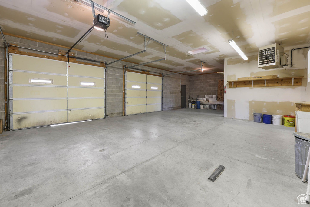 Garage featuring a garage door opener and a heating unit