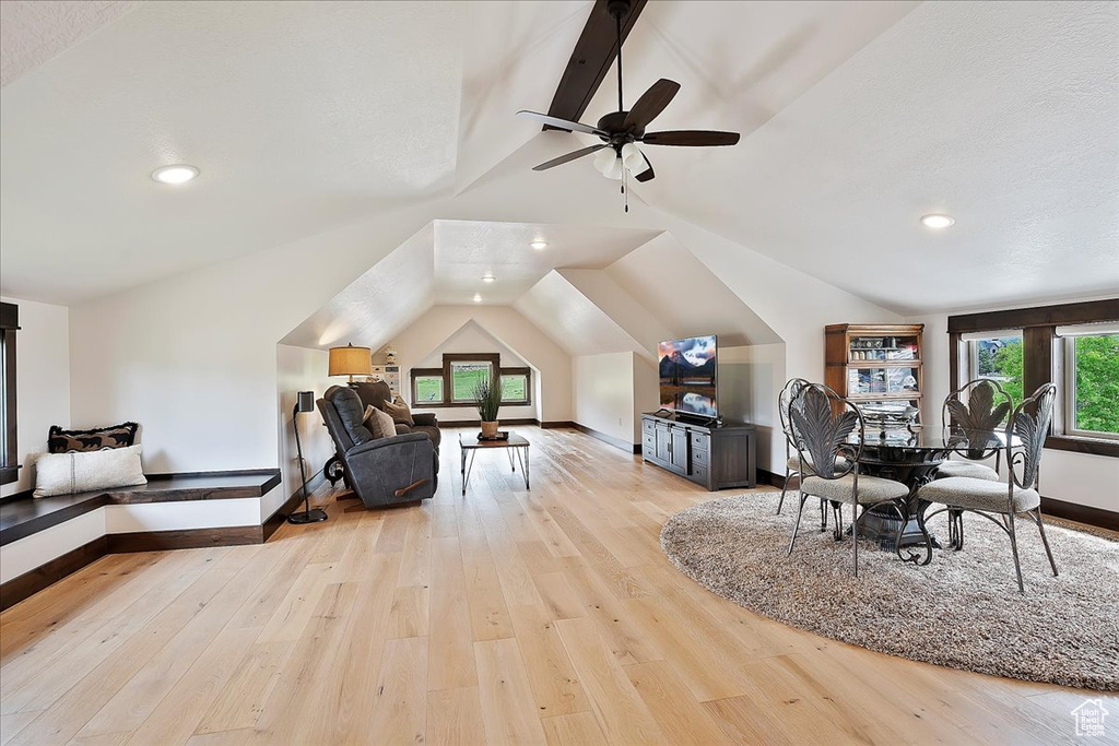 Dining room with vaulted ceiling, healthy amount of natural light, light wood-style flooring, baseboards, and a ceiling fan