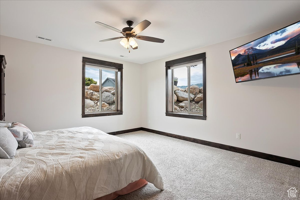 Bedroom featuring carpet floors, baseboards, and ceiling fan
