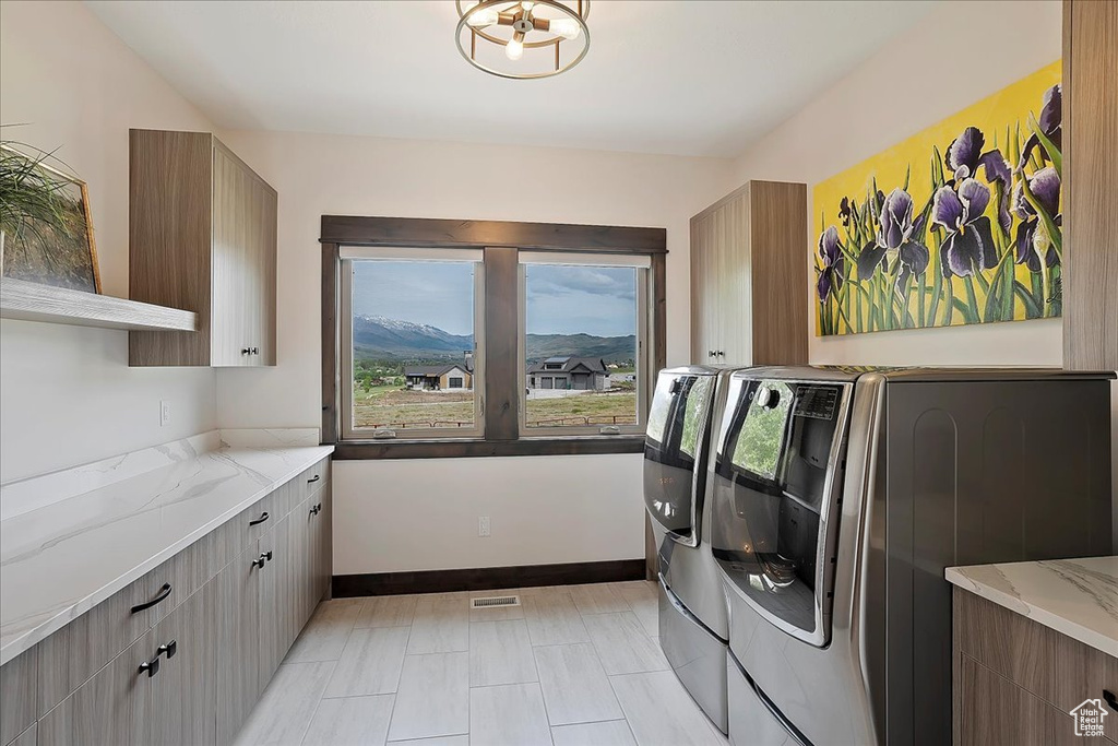 Washroom with washing machine and dryer, cabinet space, and baseboards