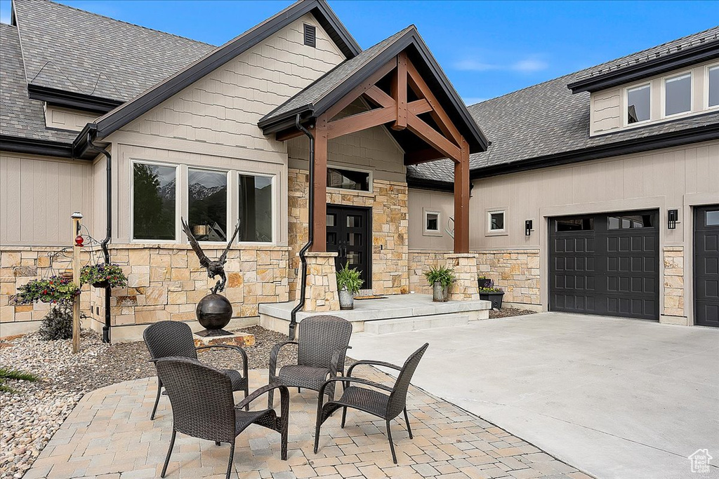 View of patio featuring driveway and a garage