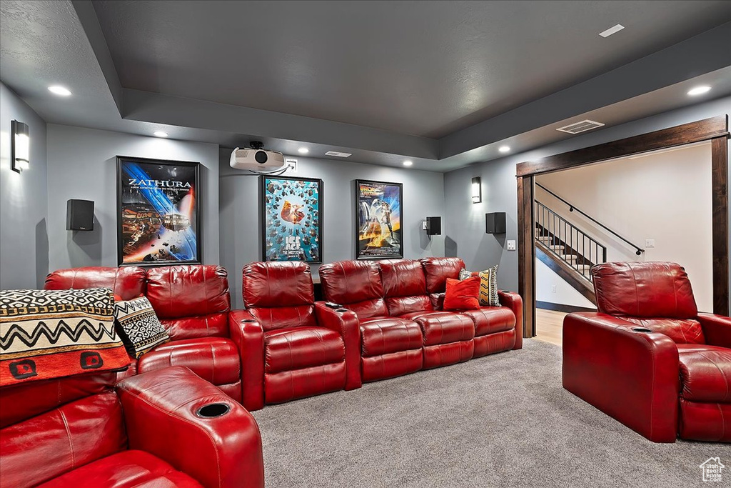 Carpeted home theater room with recessed lighting and a raised ceiling