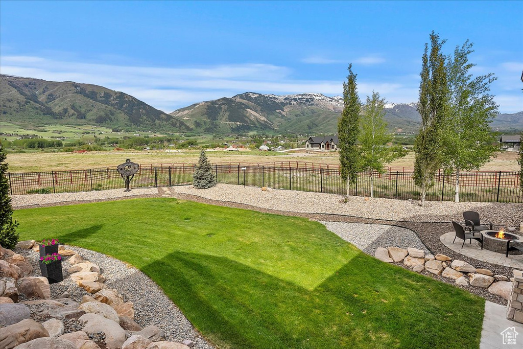 View of yard with a fire pit, a mountain view, and a patio