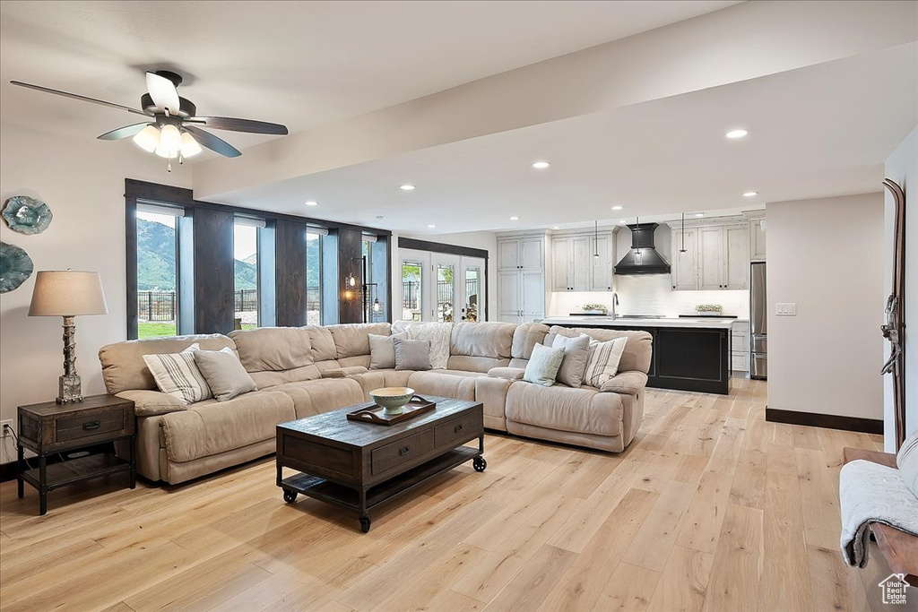 Living area with light wood-style floors, a ceiling fan, and recessed lighting