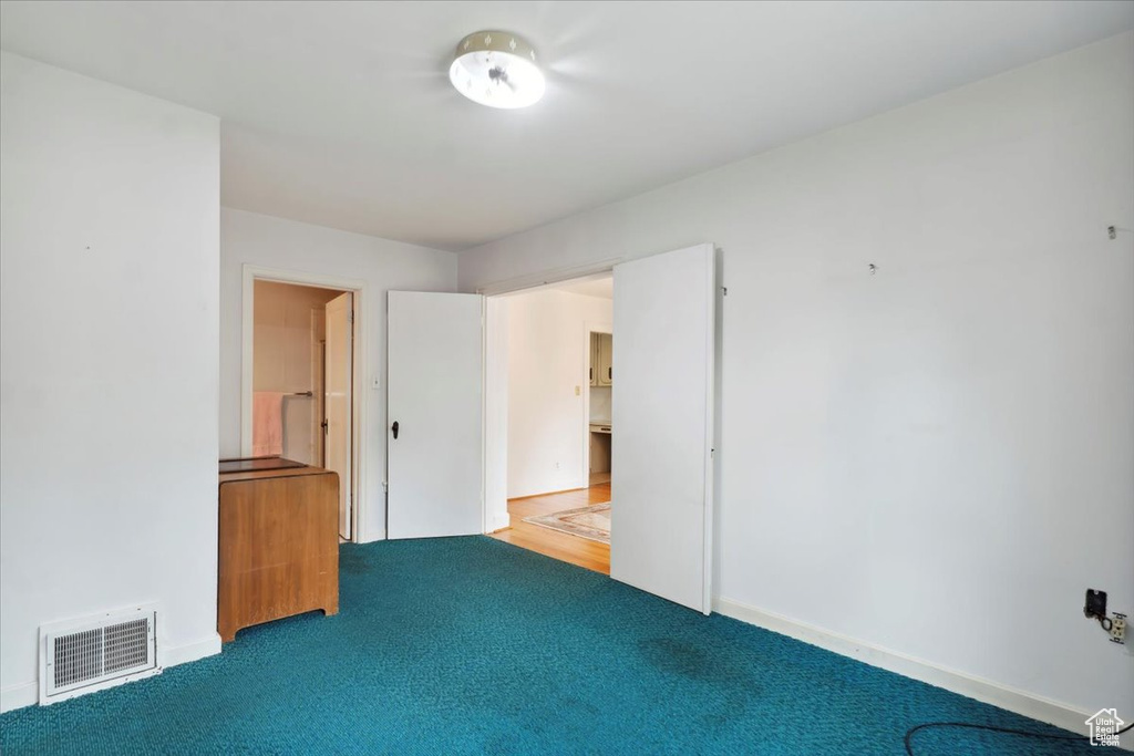 Unfurnished bedroom with carpet flooring and baseboards