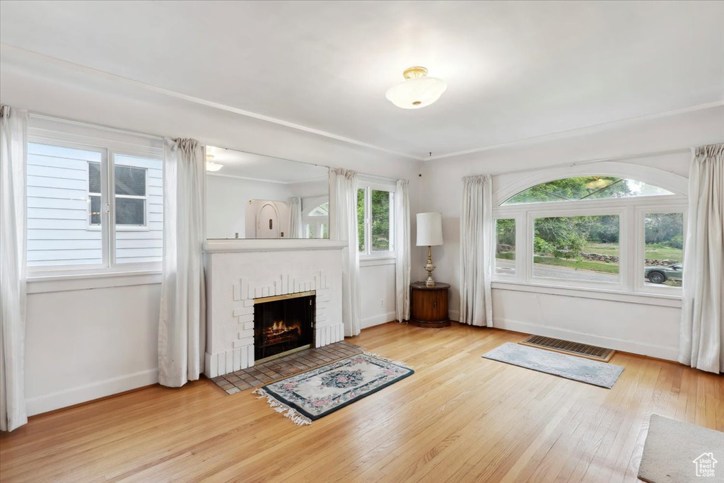 Unfurnished living room with baseboards, wood finished floors, and a fireplace