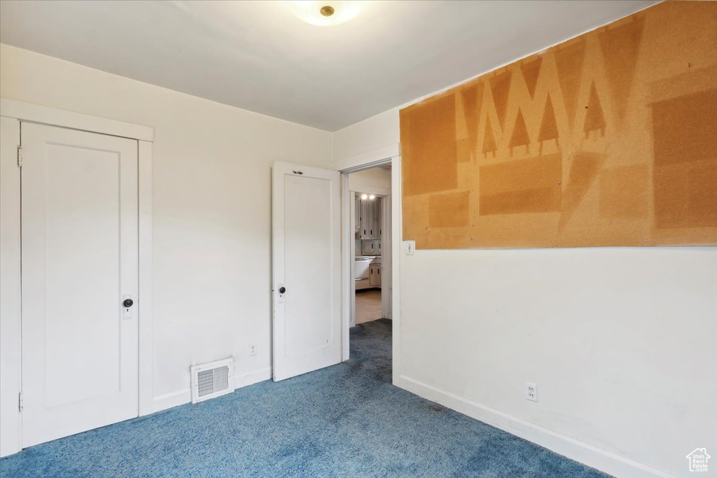 Unfurnished bedroom with carpet flooring and baseboards