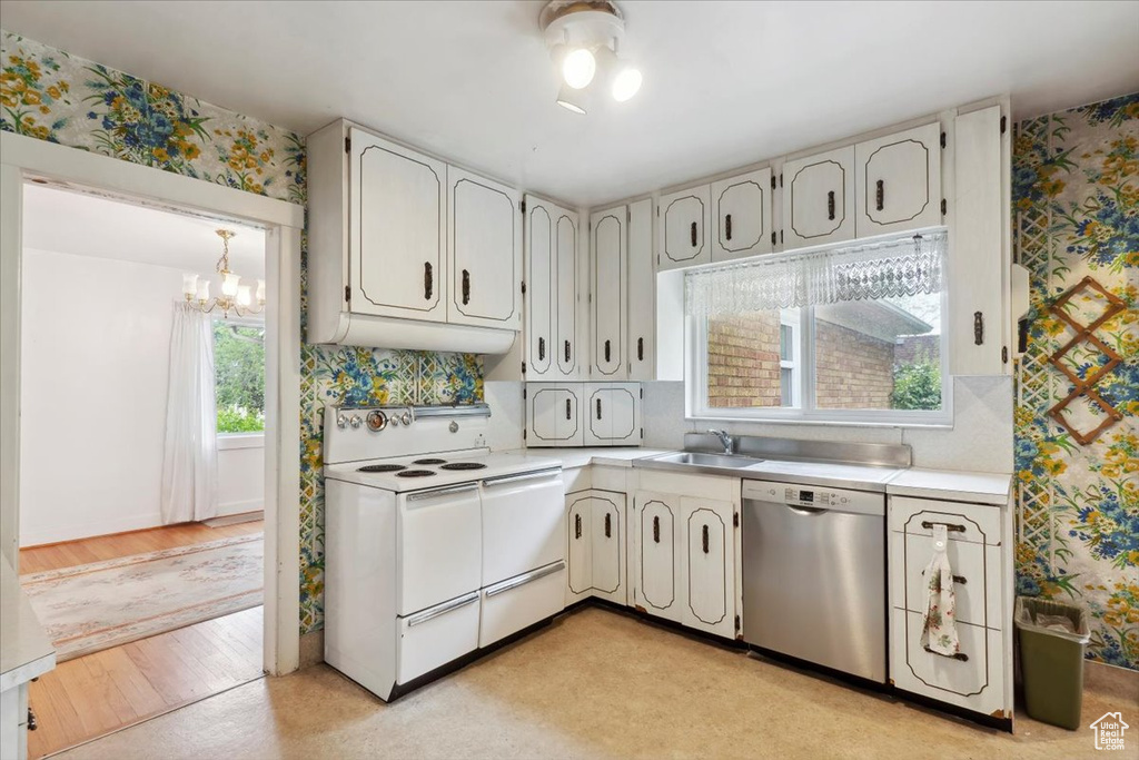 Kitchen featuring dishwasher, electric stove, a sink, wallpapered walls, and a chandelier