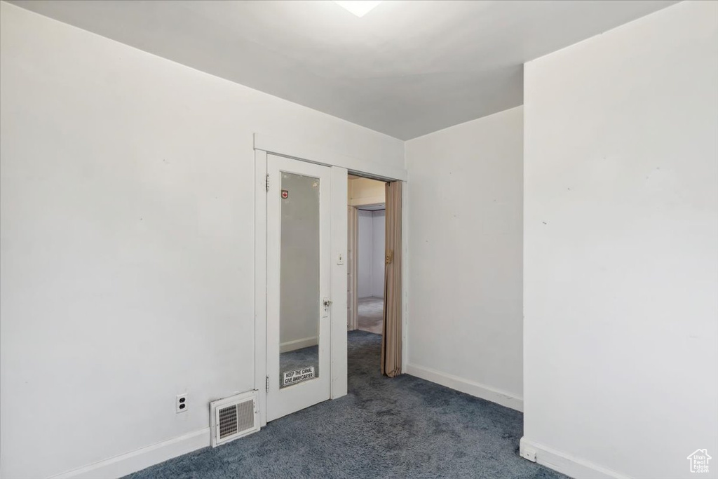 Empty room featuring carpet flooring and baseboards