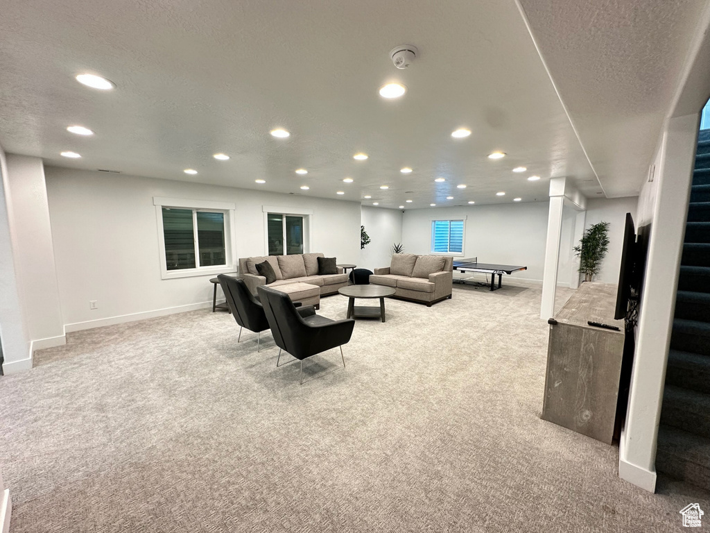 Living room featuring light colored carpet, recessed lighting, baseboards, and stairs