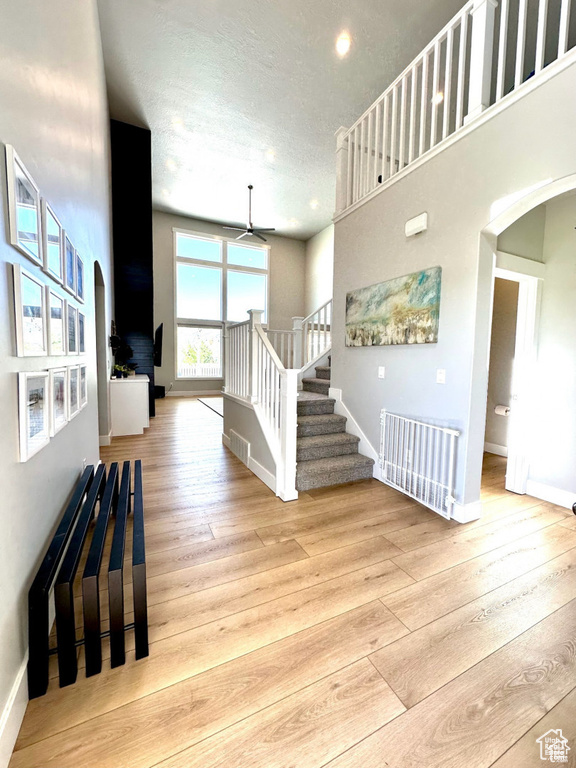 Foyer entrance with arched walkways, a ceiling fan, hardwood / wood-style flooring, and a textured ceiling