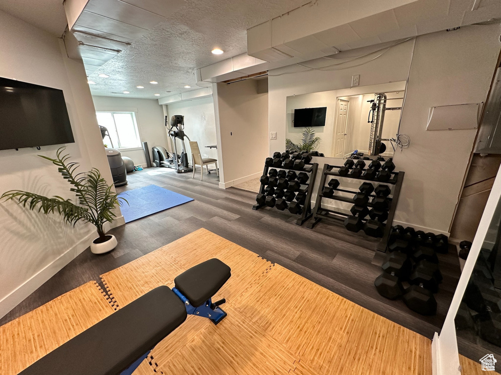 Exercise area featuring baseboards, wood finished floors, and recessed lighting