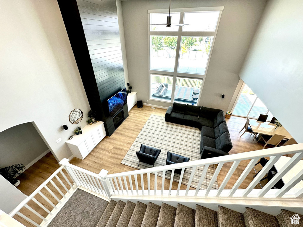 Stairway with a towering ceiling, wood finished floors, baseboards, and a fireplace