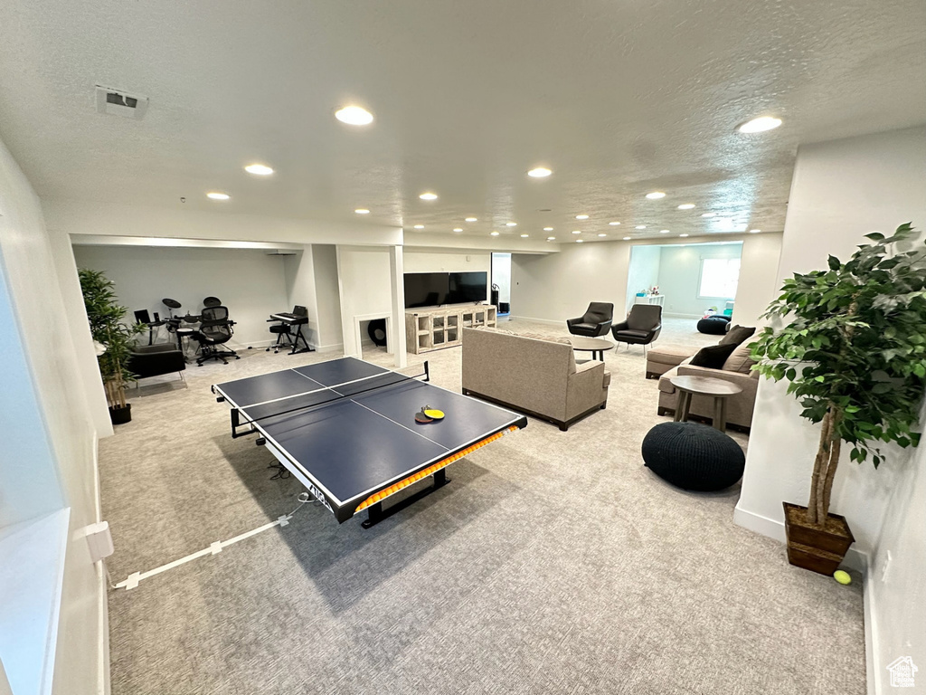 Rec room featuring light carpet, recessed lighting, a textured ceiling, and baseboards
