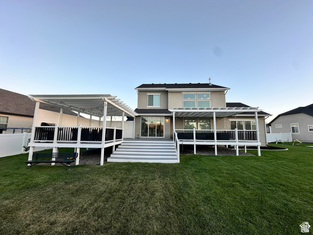 Back of property featuring a pergola and a wooden deck