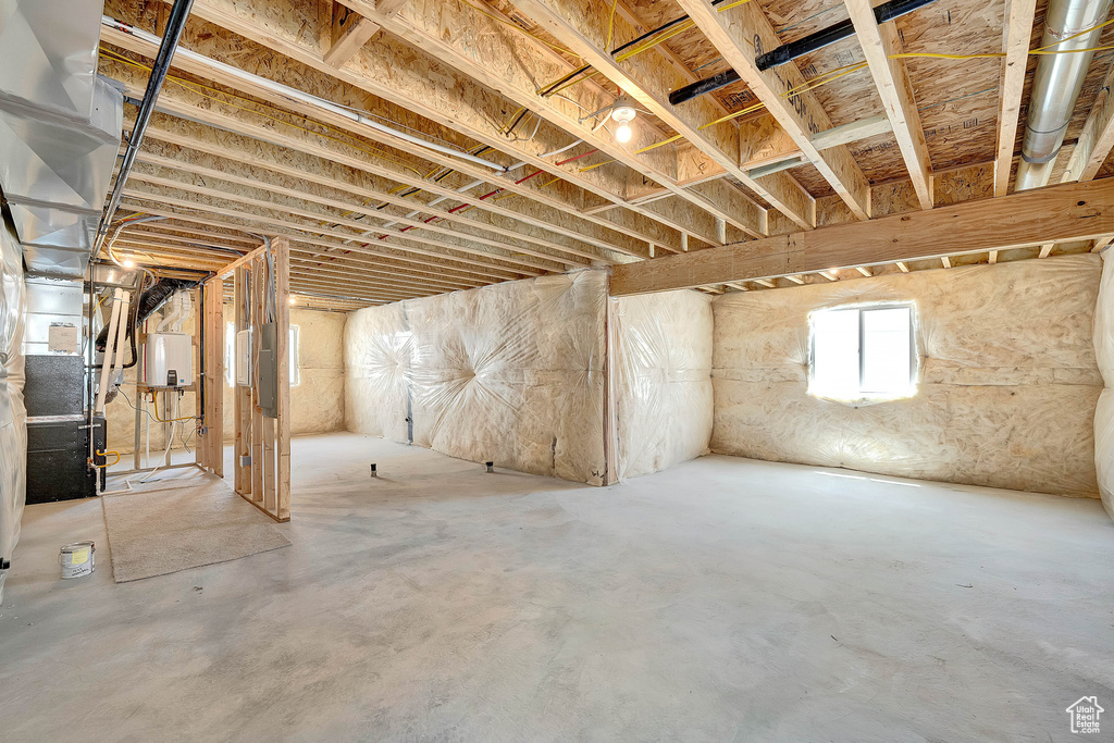 Below grade area with electric panel and water heater