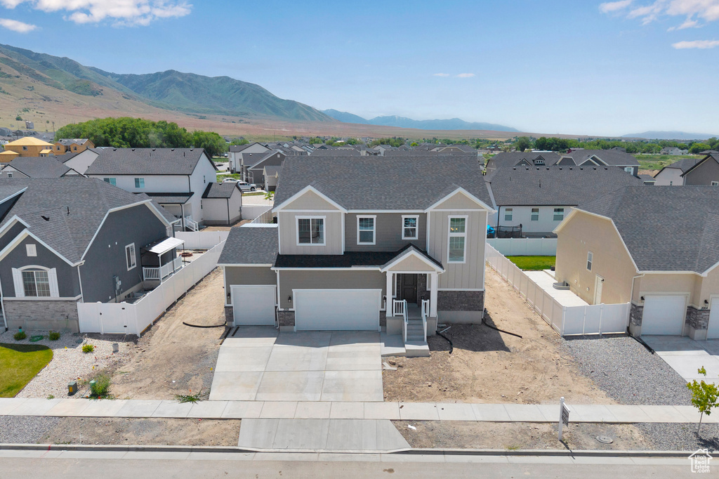 View of front of house featuring a residential view, driveway, a gate, and a garage