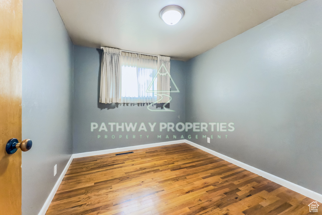 Spare room with wood finished floors and baseboards