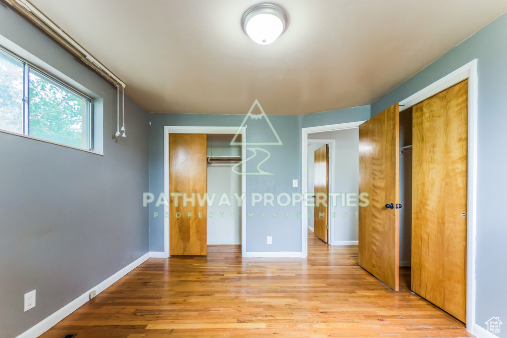 Unfurnished bedroom featuring light wood-type flooring and baseboards