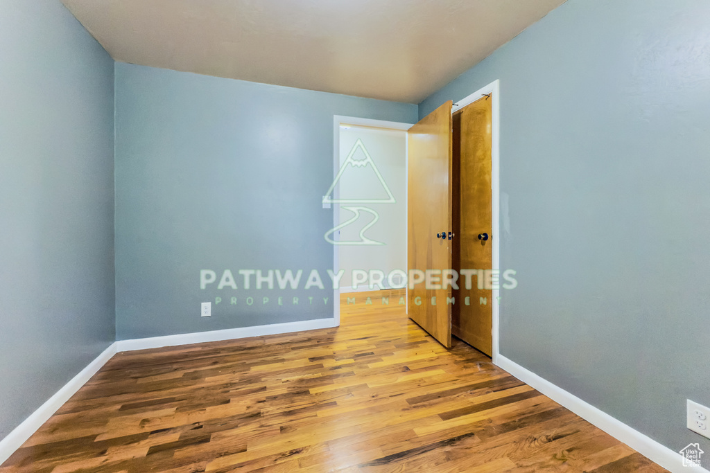 Empty room featuring wood finished floors and baseboards