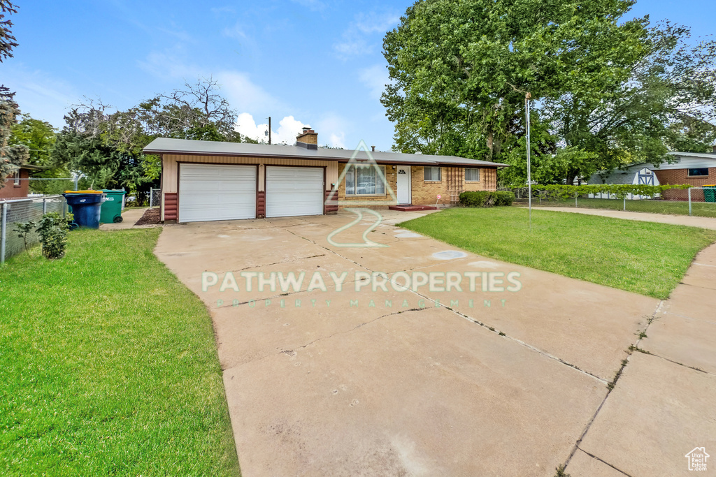 Ranch-style house with concrete driveway, a chimney, and brick siding