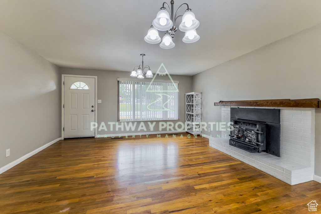 Entrance foyer with a chandelier, wood finished floors, and baseboards