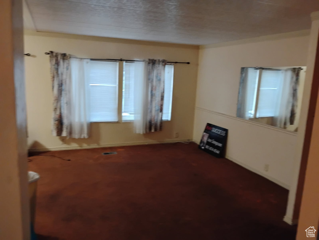 Unfurnished room with dark colored carpet