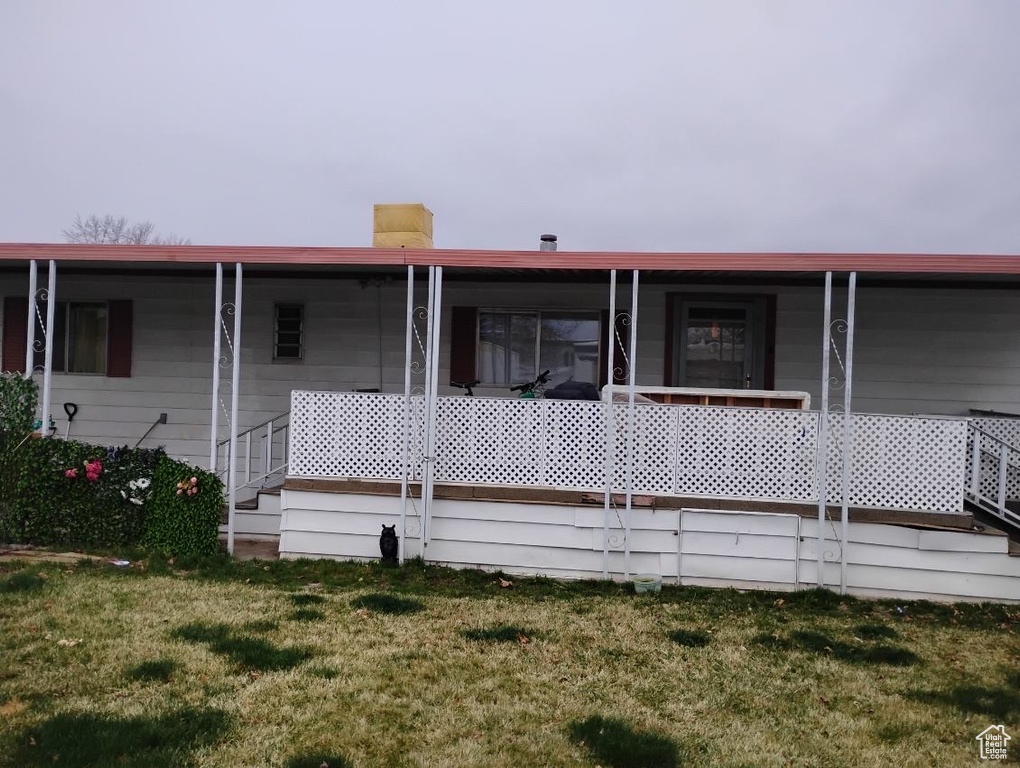 Back of property featuring a yard and a chimney