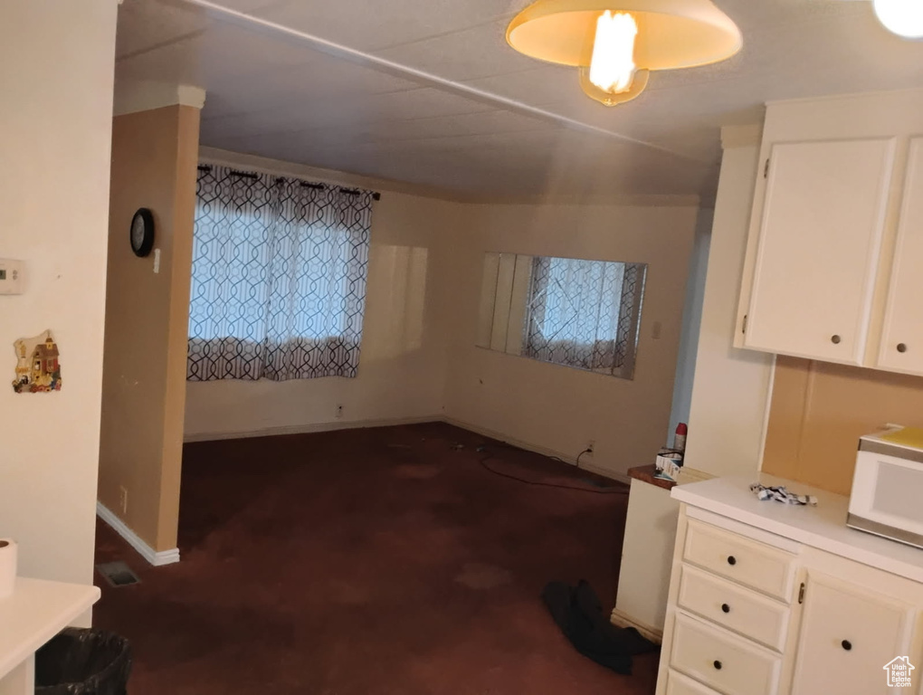 Unfurnished dining area featuring dark colored carpet