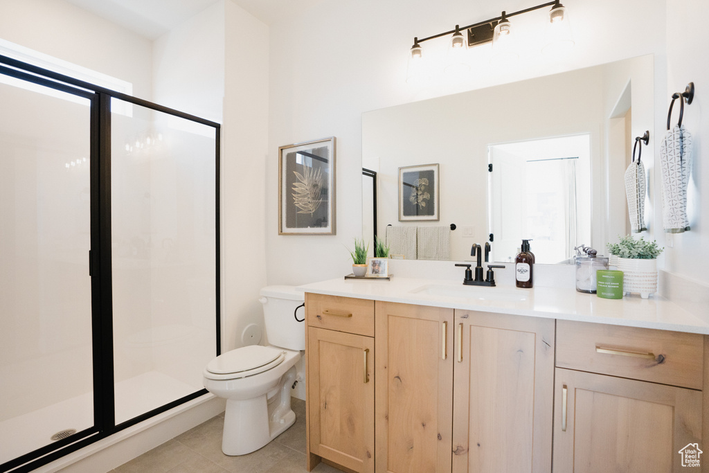 Bathroom featuring toilet, a shower stall, tile patterned floors, and vanity