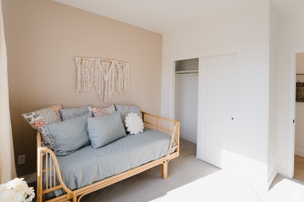 Carpeted bedroom featuring a closet and baseboards