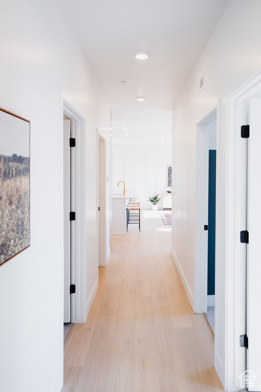Corridor with light wood finished floors and baseboards