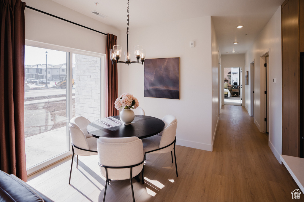 Dining space with a chandelier, light wood-style flooring, baseboards, and recessed lighting