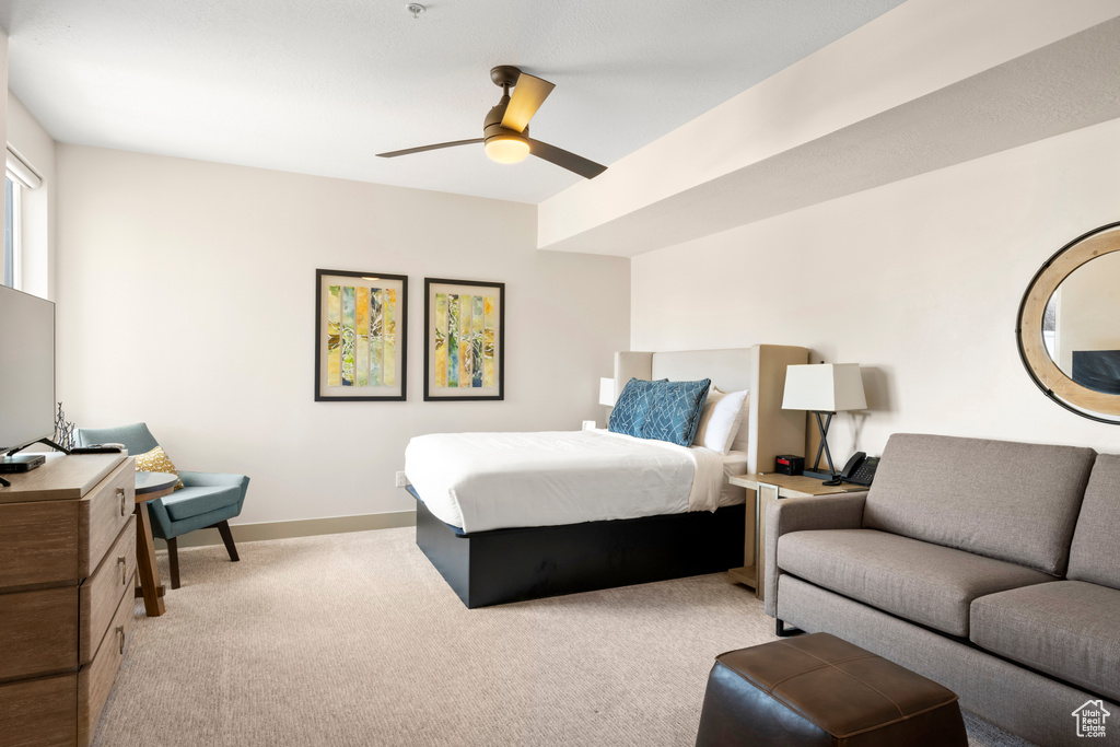 Bedroom featuring light carpet, baseboards, and a ceiling fan