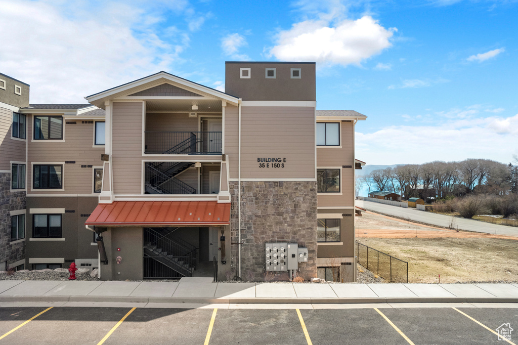 View of building exterior featuring uncovered parking and stairs
